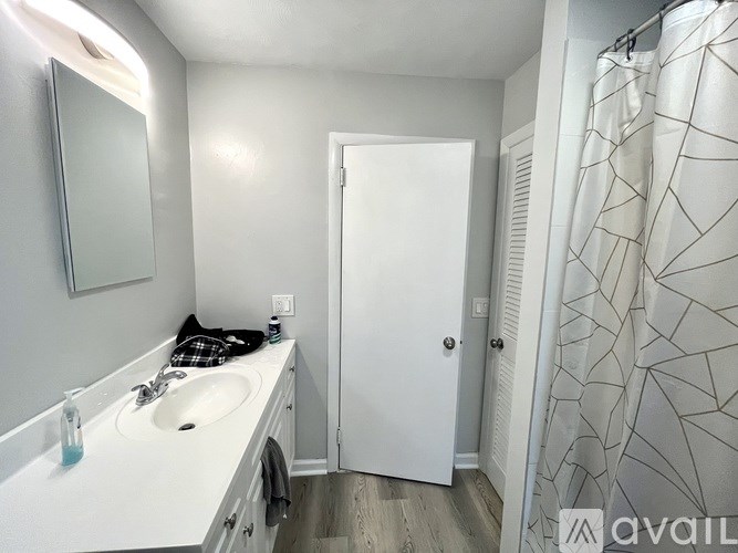 A bathroom with a white sink and a white door.