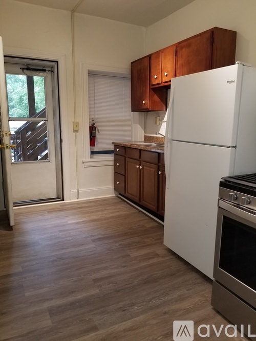 A kitchen with a white fridge and wooden cabinets.