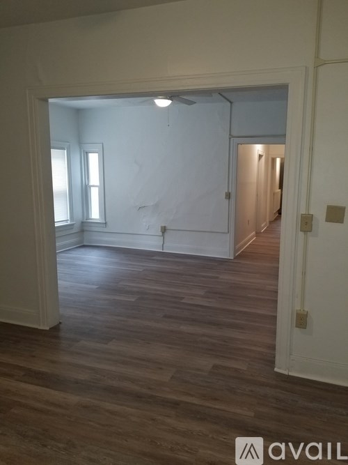 A room with wooden flooring and white walls.
