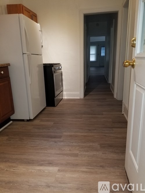A kitchen with a white fridge and a white door.