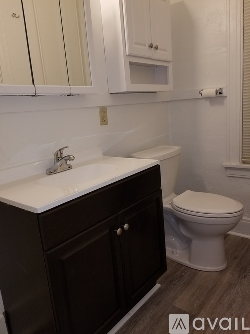 A white toilet sits next to a sink in a bathroom.