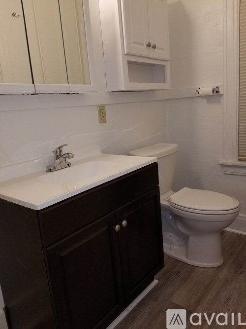 A white toilet sits next to a sink in a bathroom.