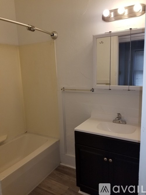 A bathroom with a white sink and a white bathtub.