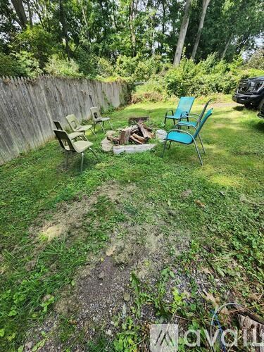 A backyard with a fire pit and chairs.