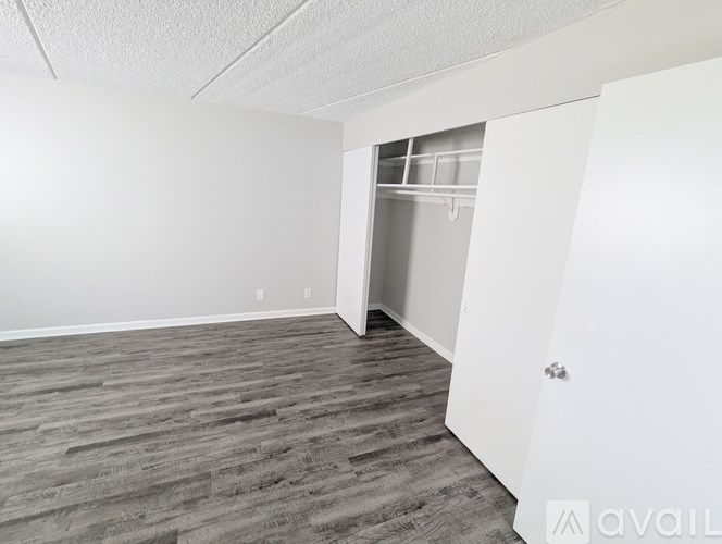 A room with a white ceiling, a grey floor, and a white door.
