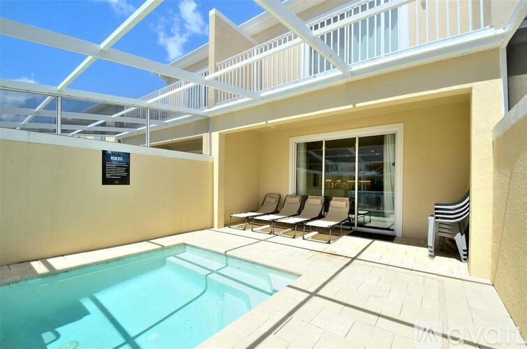 A pool area with a glass enclosed pool and sun loungers.