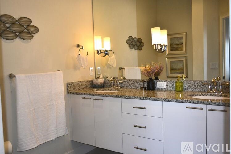 A bathroom with a white towel hanging on the shower curtain.