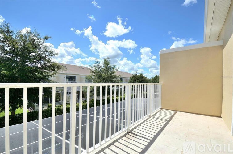 A balcony with a white railing and a building in the background.