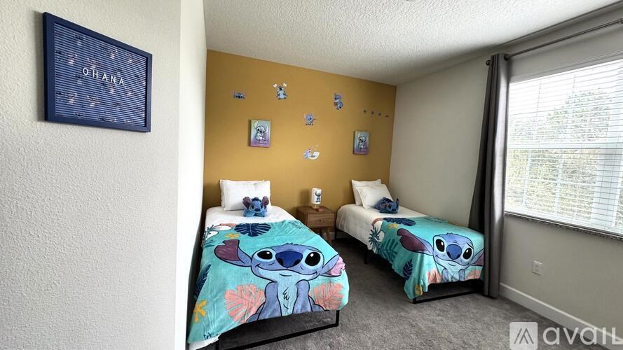 A room with two beds and a sign that says "O'hana" on the wall.