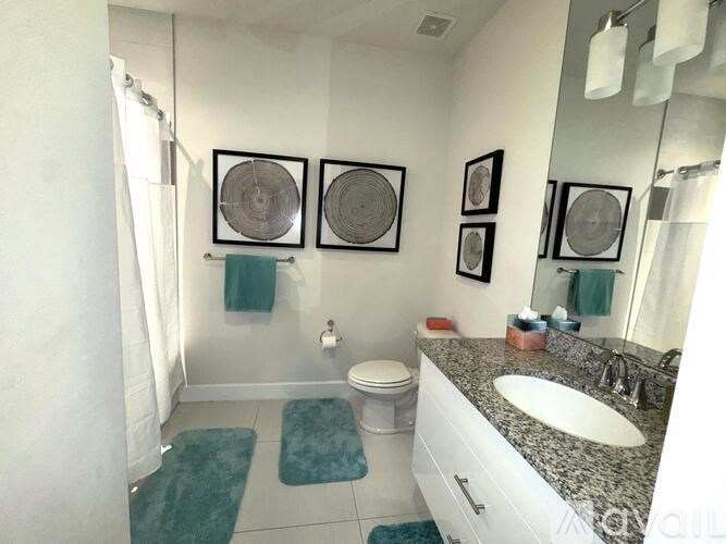 A bathroom with a toilet, sink, and mirror.