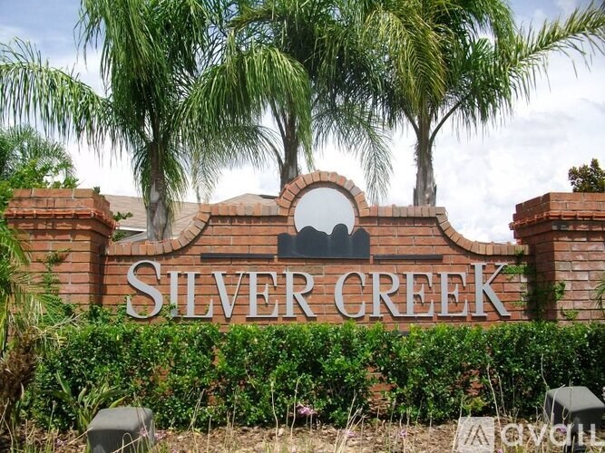A sign that says Silver Creek in front of some trees.