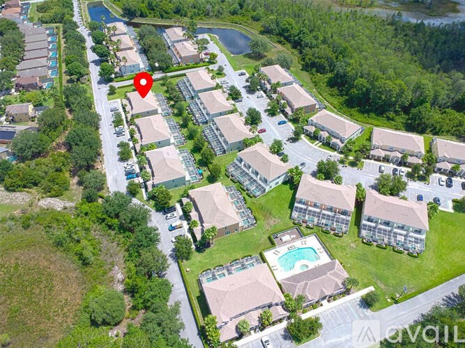 An aerial view of a residential area with a swimming pool and a road.