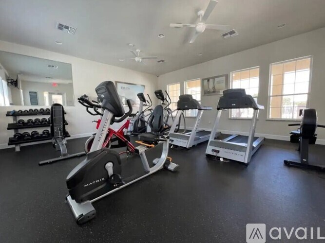 A gym with a variety of exercise equipment including treadmills, stationary bikes, and weight machines.