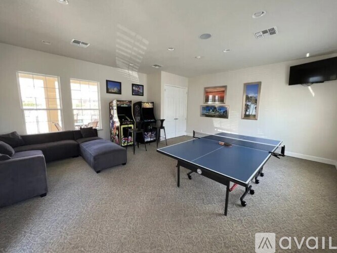 A spacious living room with a ping pong table in the center.