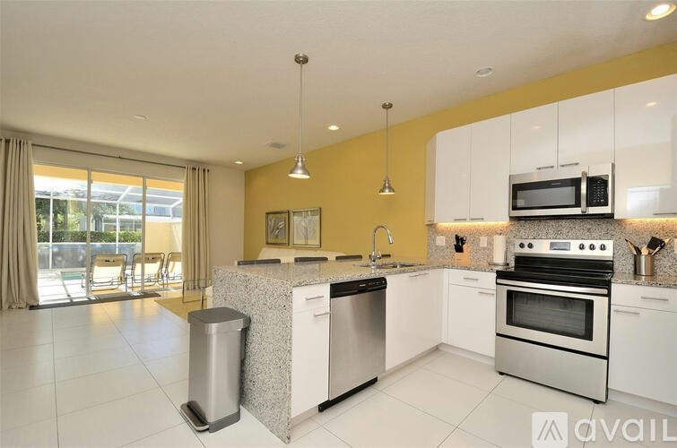 A kitchen with yellow walls and white cabinets.