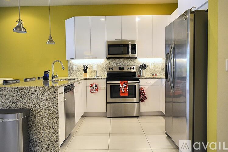 A modern kitchen with a stainless steel refrigerator and a yellow backsplash.