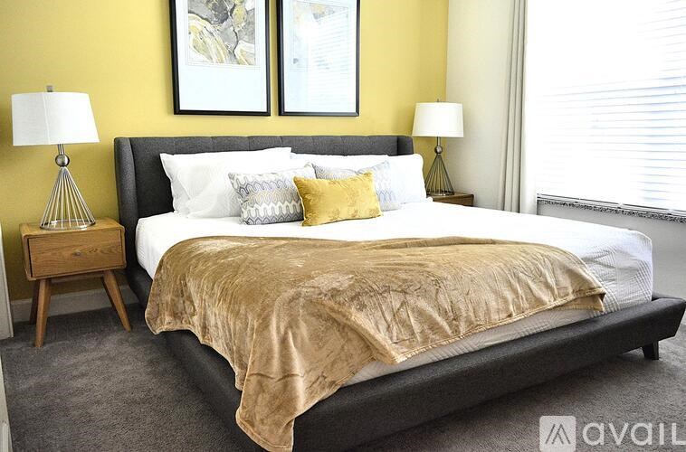 A bedroom with a large bed and two lamps.