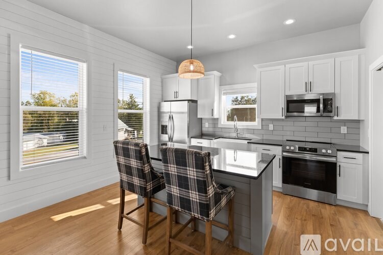 A kitchen with a checkered chair and a window.