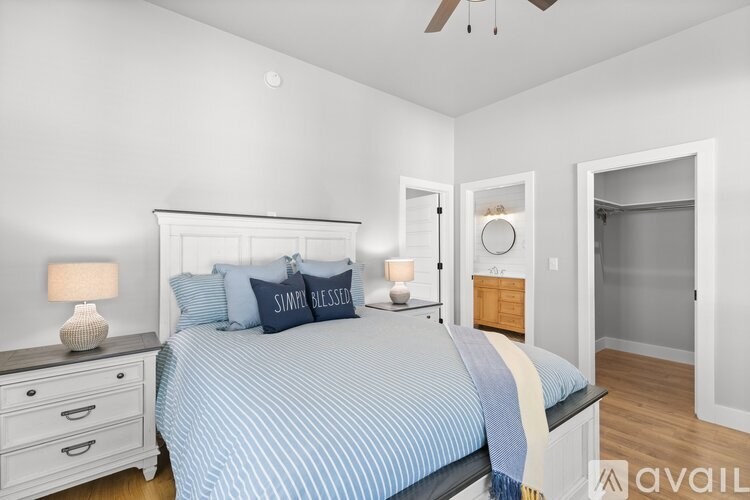 A bedroom with a bed, nightstand, and a ceiling fan.