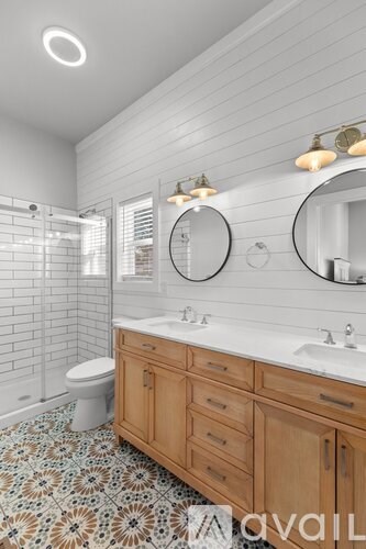 A bathroom with a toilet, sink, and mirror.