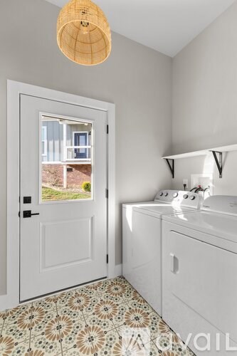 A bathroom with a white door and a window showing a view of a house.
