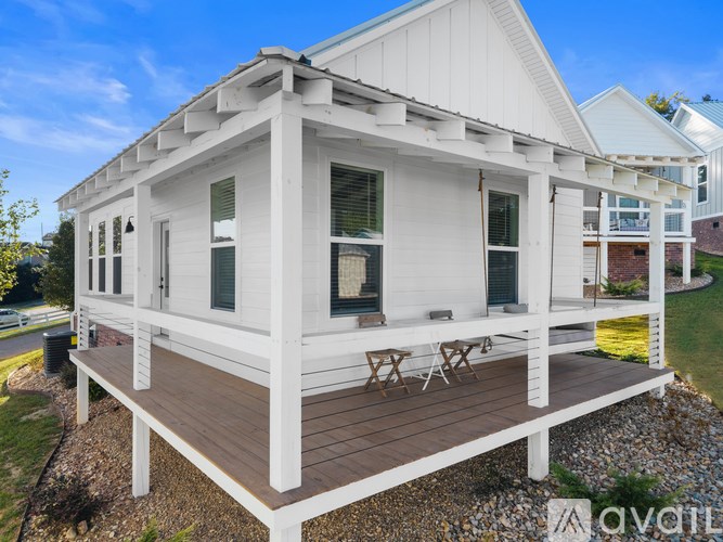 A white house with a deck and a patio table.