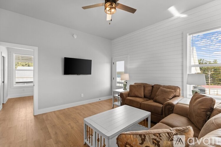 A living room with a flat screen TV mounted on the wall.