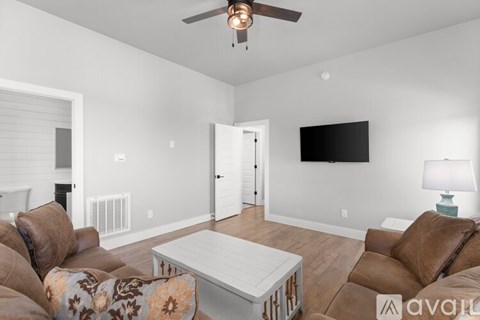 A living room with a white coffee table and brown leather couches.