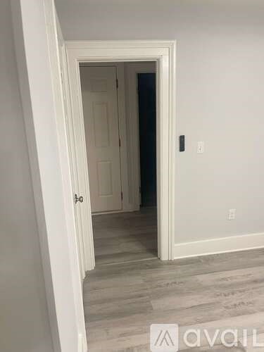 A white door is open to a darker room.