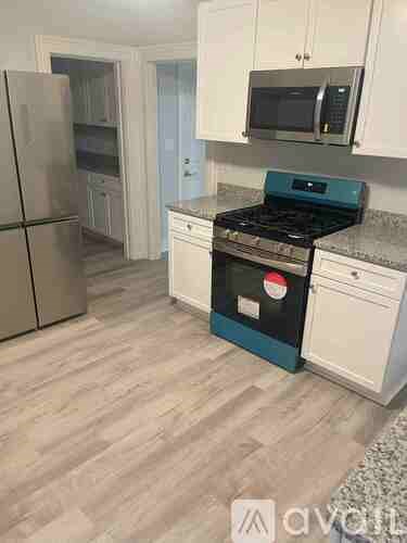 A kitchen with a stove top oven and a refrigerator.