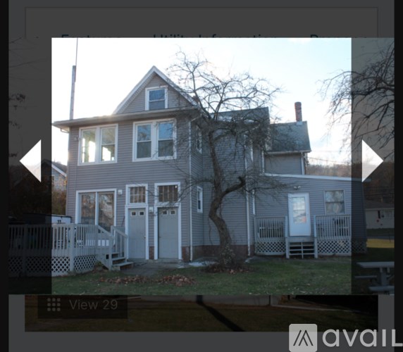A house with a grey facade and a tree in front.