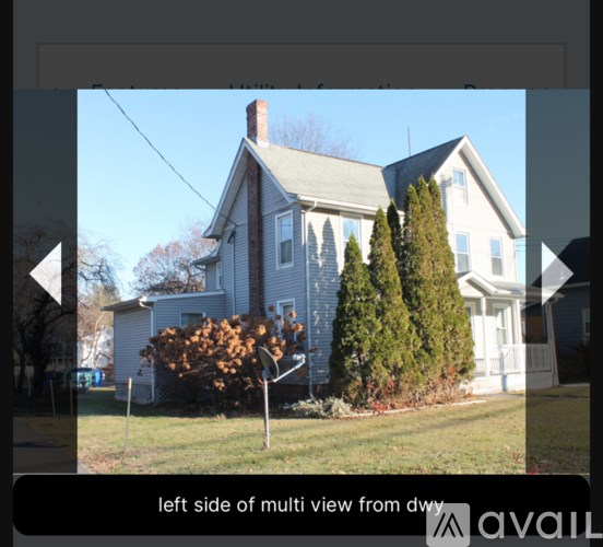 A house with a grey roof and white walls is shown from the left side.
