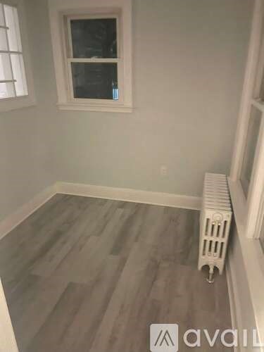 A room with a window and a radiator on the floor.