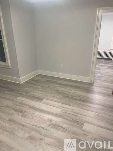 A room with a wooden floor and white walls.