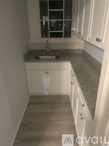 A kitchen with white cabinets and a granite countertop.