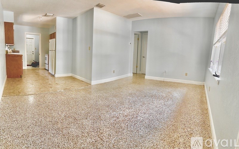 A large empty room with a speckled floor.