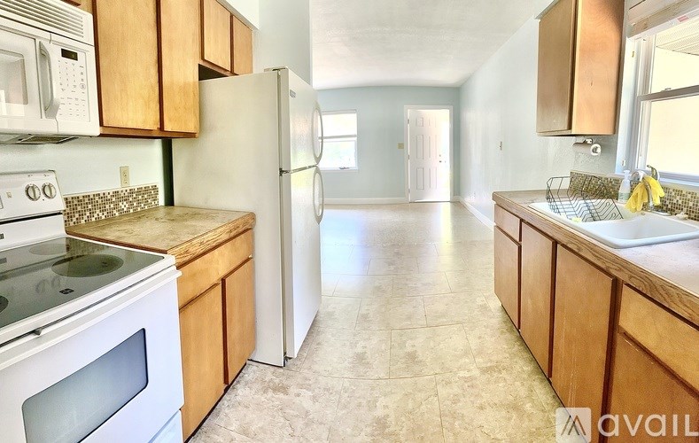 A kitchen with wooden cabinets and a tiled floor.