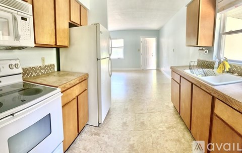 A kitchen with wooden cabinets and a tiled floor.