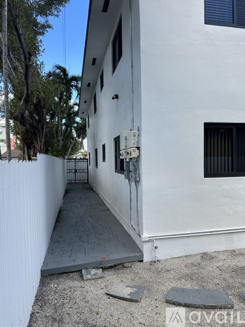 A white building with a gate and a window.