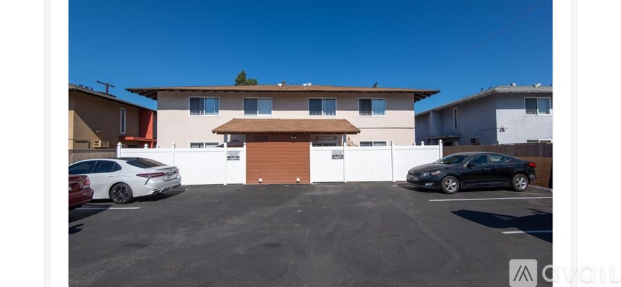 A white car is parked in front of a garage.
