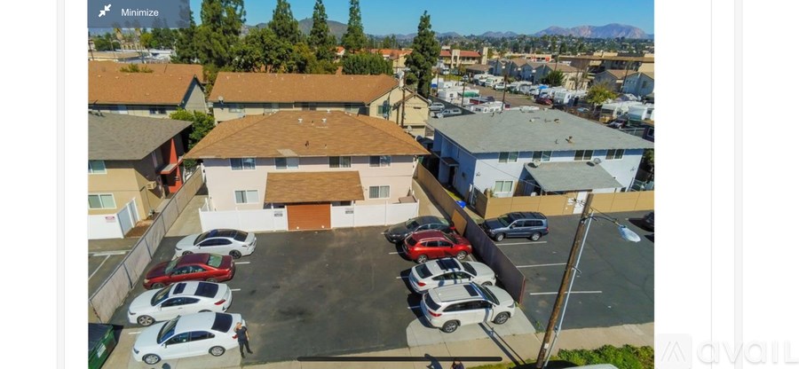 A parking lot with cars and a building in the background.