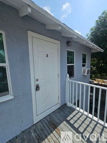A small house with a white door and a porch.
