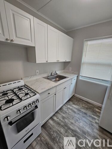 A kitchen with a white stove and cabinets.