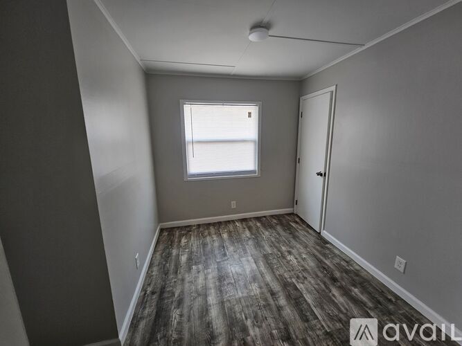 A room with a window and wooden flooring is available for rent.