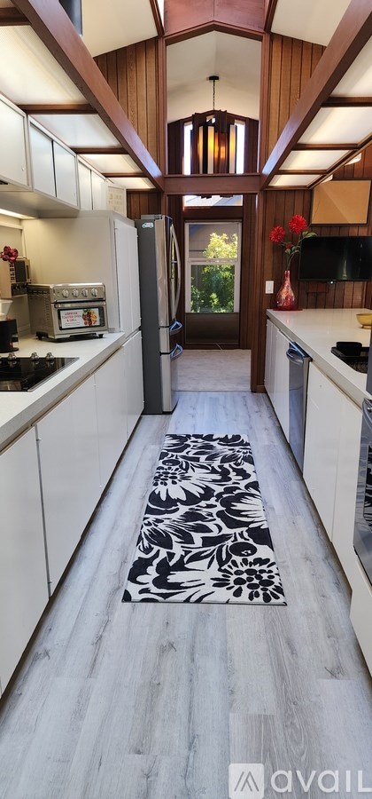 A kitchen with a black and white patterned runner on the floor.