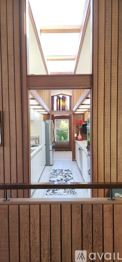 A hallway with wooden walls and a skylight.