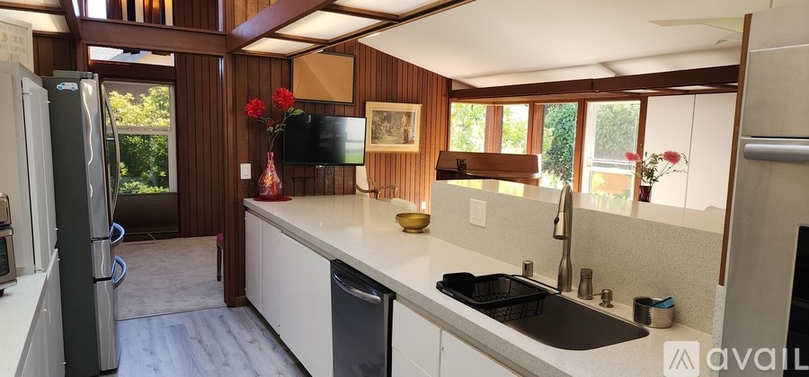 A kitchen with a black fridge and a black dishwasher.