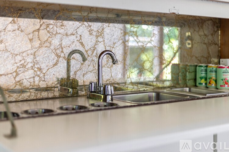 A kitchen counter with a sink and a window in the background.
