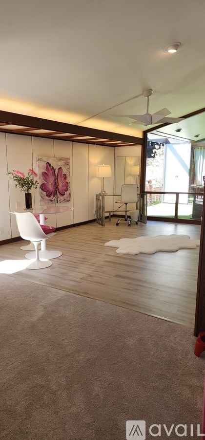 A room with a ceiling fan and a painting on the wall.