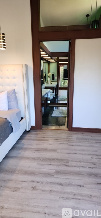 A bedroom with a bed and a wooden floor.